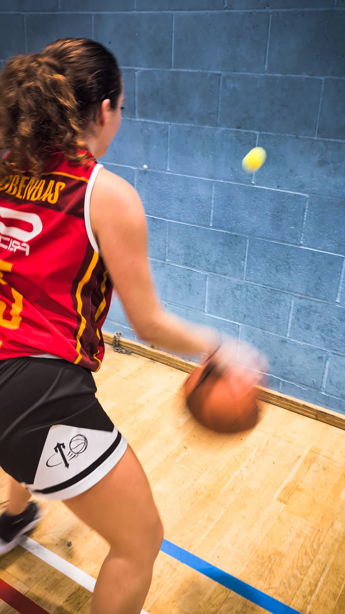 Athlete doing a reaction-ball dribbling drill against the wall