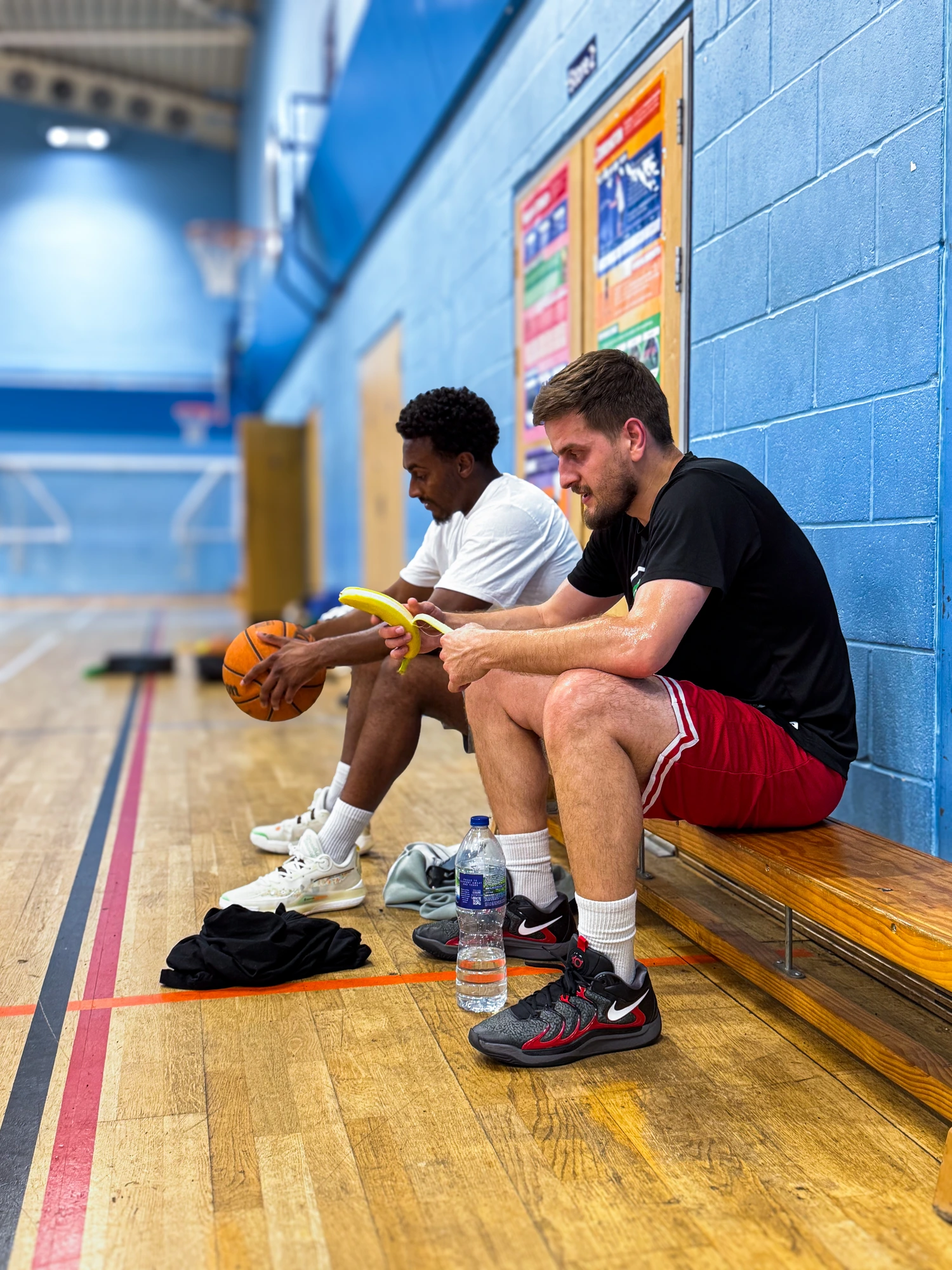 Athletes refuelling with water and a banana on the bench